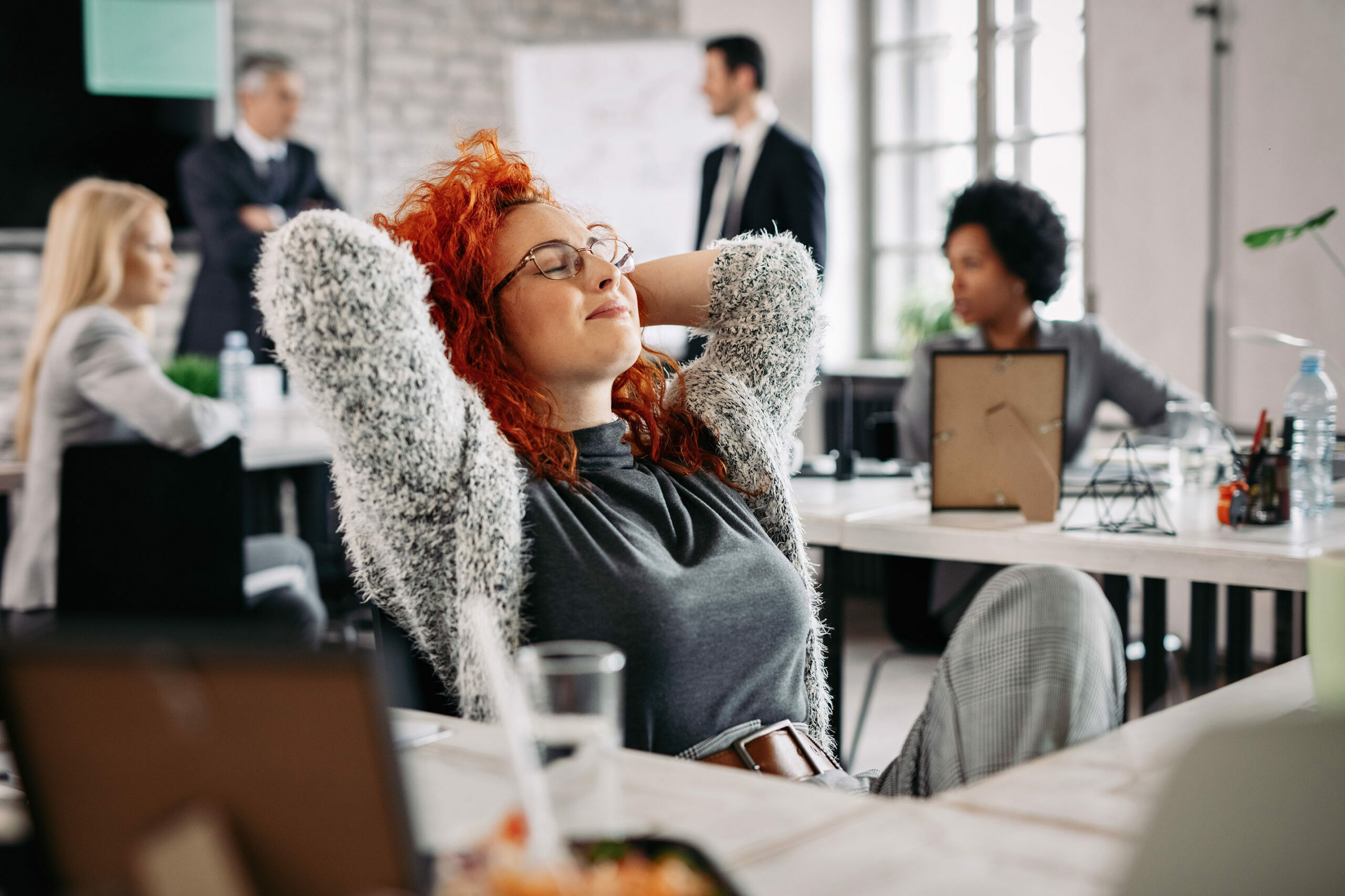 young-creative-businesswoman-with-hands-head-taking-break-resting-with-eyes-closed-office2